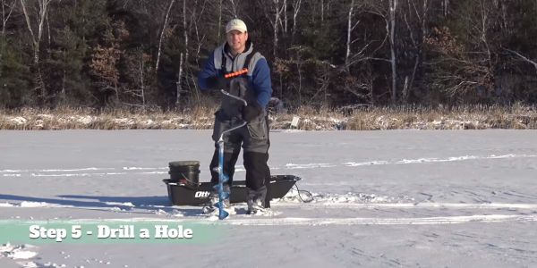 男人拿着冰上钓鱼钻188bet亚洲体育真人投注