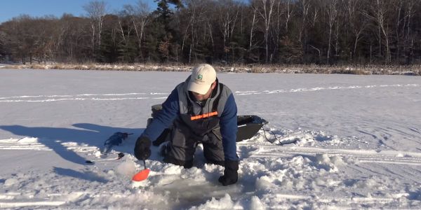 男子冰上钓鱼孔铲冰泥188bet亚洲体育真人投注