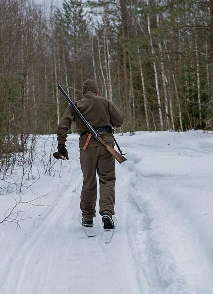 拿着猎枪在雪地里滑雪的人澳门188bet开户注册